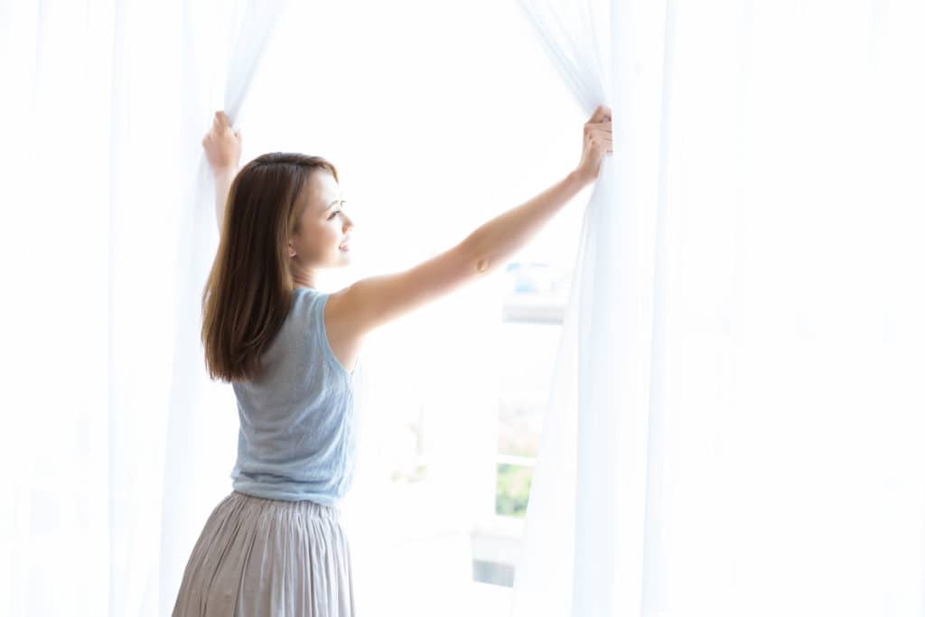 woman opening castle windows blinds