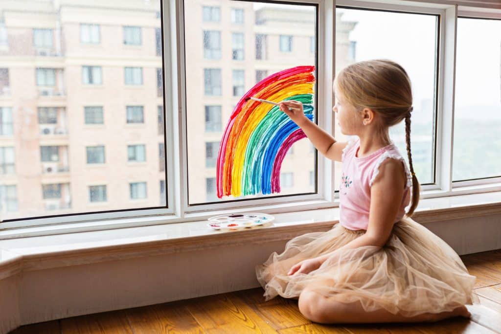 little girl paints window